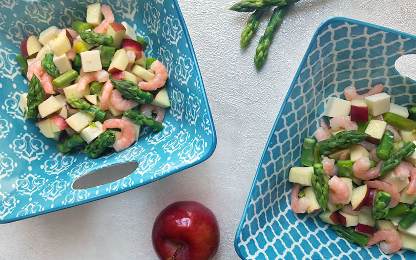Deux bols bleus de salade estival aux crevettes, pommes, asperges et fromage